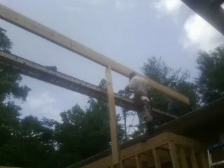 Carpenter setting a ridge beam over a new addition frame — Ice Dam Removal by Roofing Brothers in Fromberg