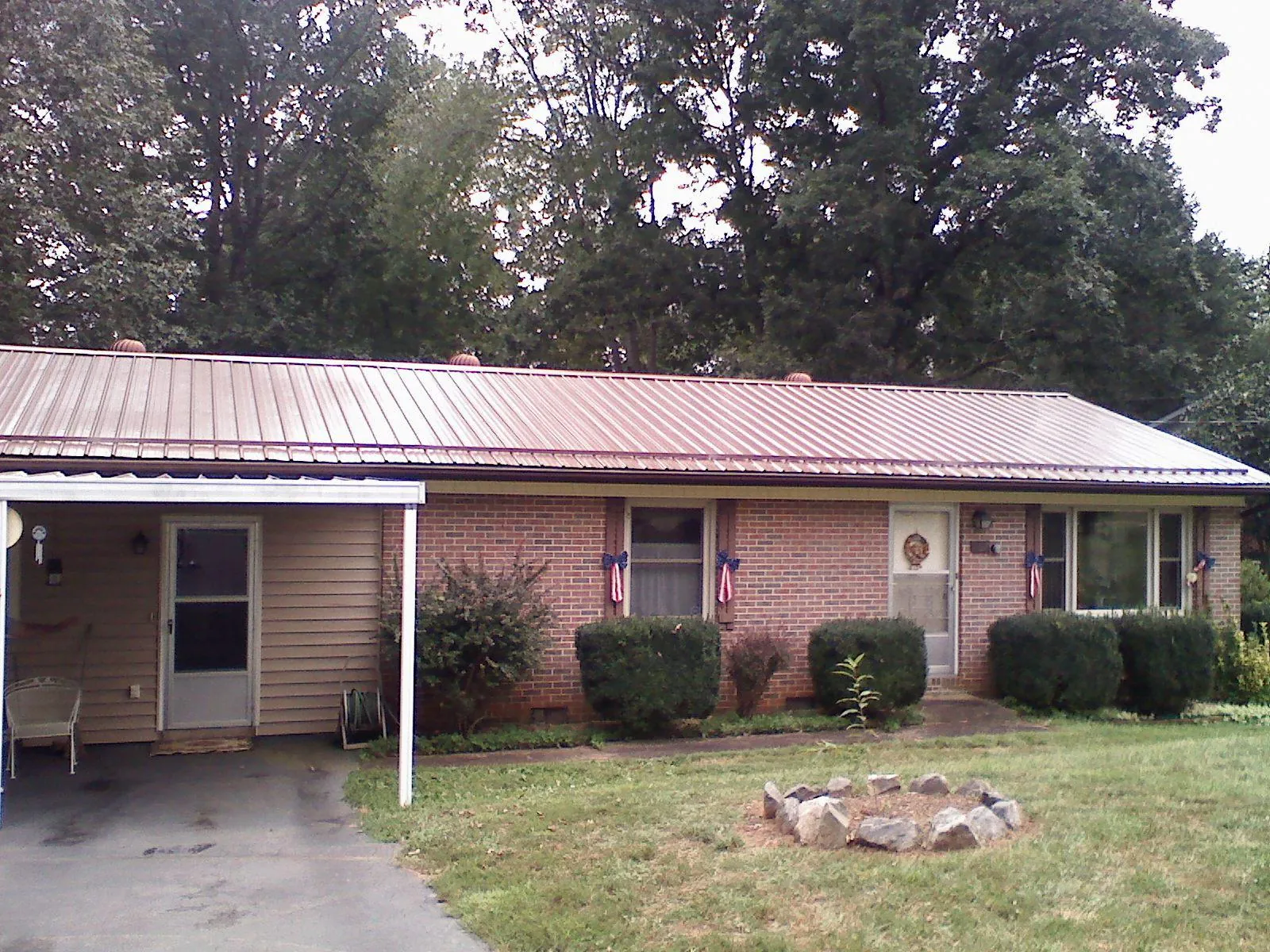 Bronze metal roof and carport on a brick ranch home — Roof Repair work by our crew in Fromberg